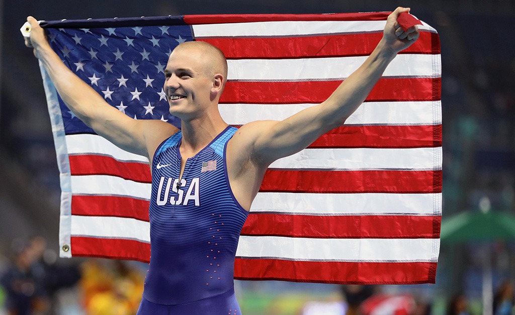 Sam Kendricks holds an American flag taut behind his back