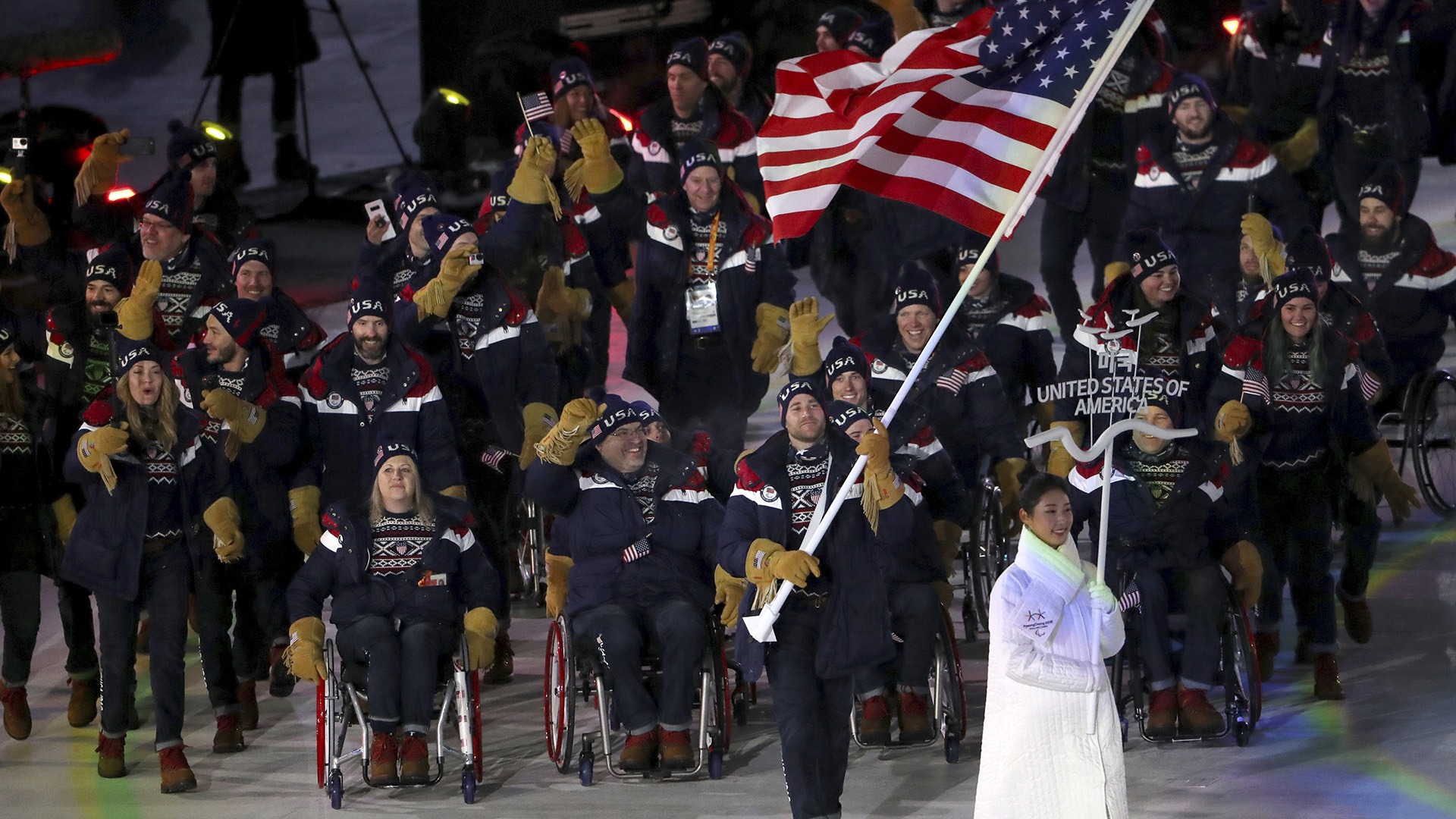 Mike Schultz carries the flag of the United States as he leads his delegation into the opening ceremony.