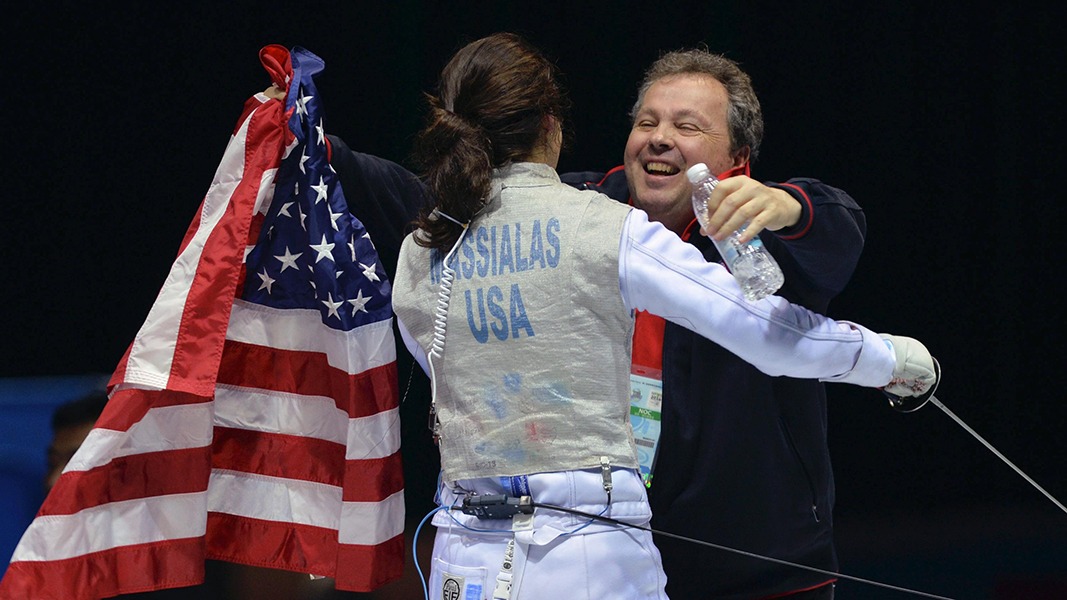 Coach Greg Massialas hugs his daughter Sabrina after her match