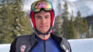Tyler Carter poses on a mountain, ski goggles on his head