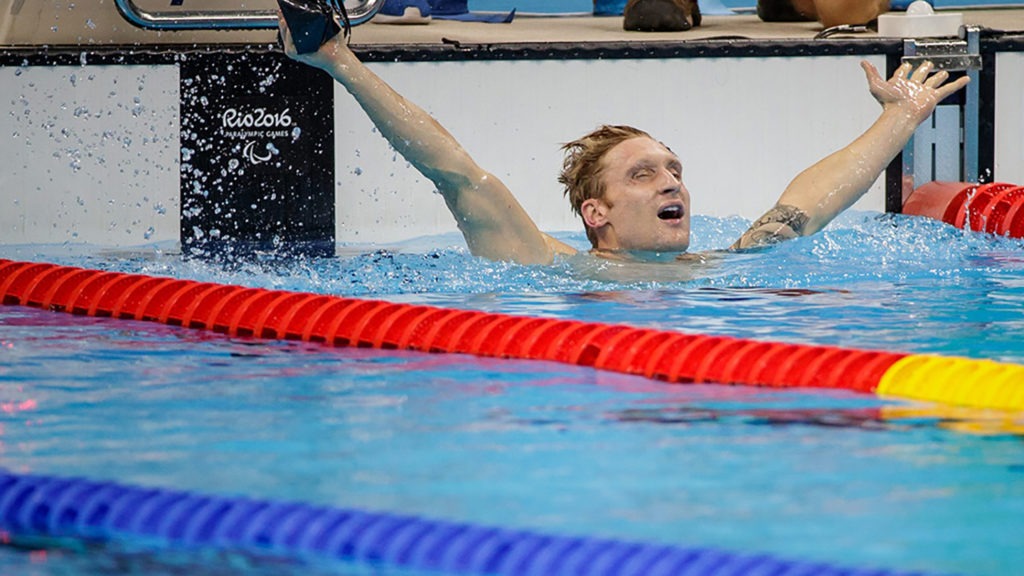 Brad Snyder exults upon winning gold, raising both of his arms in the air.