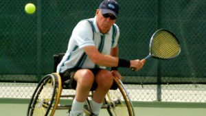As the tennis ball approaches, Bruce Karr steadies his wheelchair and gets ready to swat a backhand.