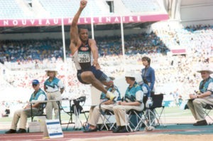 John Register soars in the air and past judges during the long jump at Sydney 2000