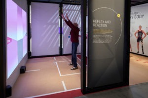 Man enjoys react exhibit at United States Olympic and Paralympic Museum.