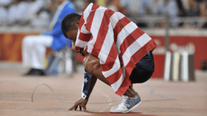 Bryan Clay kneels, overwhelmed with emotion by his victory