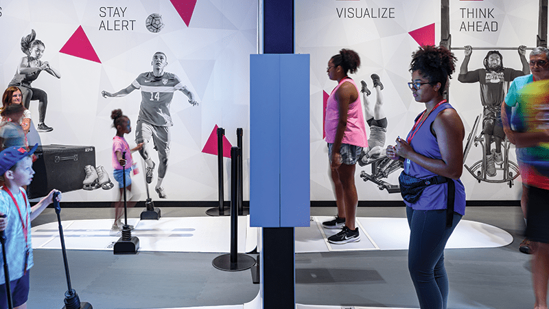 Guests using the interactive exhibits in the Athlete Training gallery
