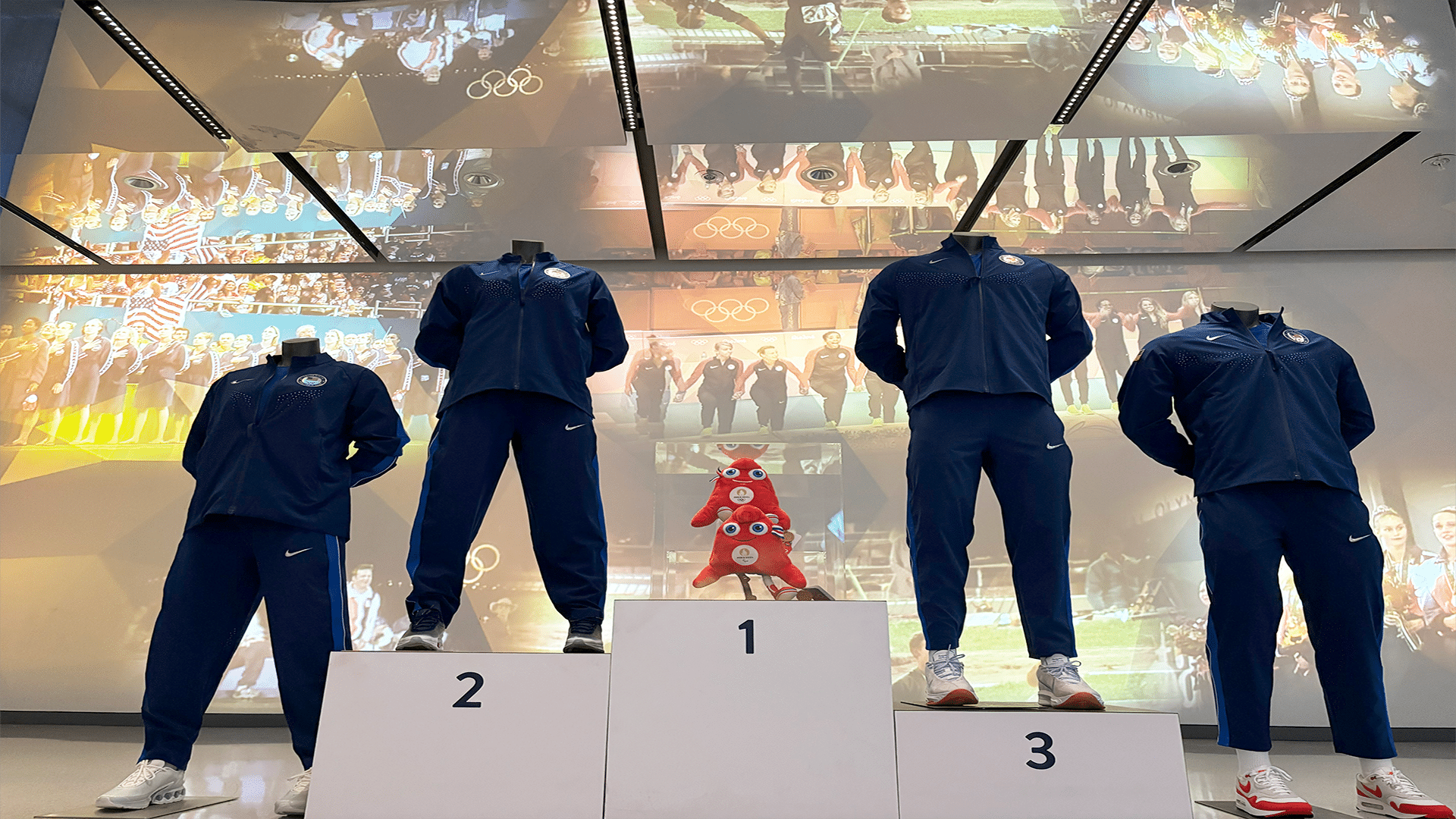 Picture of the 2024 Paris medal ceremony kits with a backdrop of videos from medal ceremonies